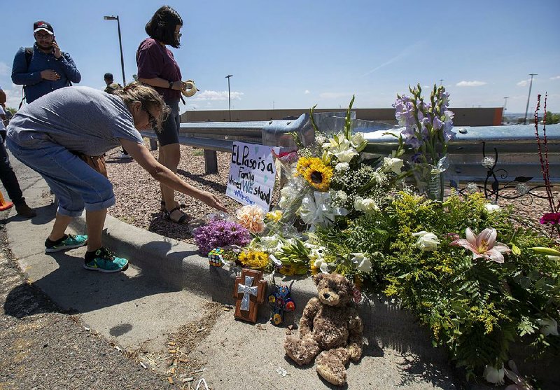 Residents of El Paso, Texas, place flowers at a makeshift memorial Sunday for victims of Saturday’s mass shooting at a shopping complex in the city. 