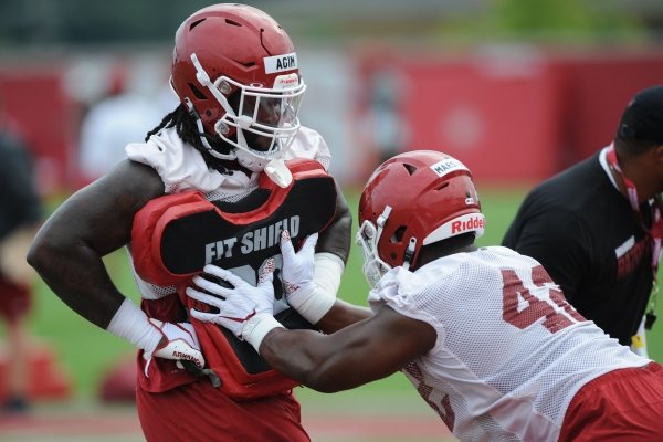 Arkansas defensive lineman McTelvin Agim (left) holds a blocking shield Friday, Aug. 2, 2019, for Jonathan Marshall during practice at the university practice field in Fayetteville. Visit nwad.com/photos to see more photographs from the practice.