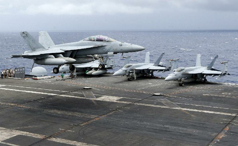 A U.S. fighter lands on the deck of the USS Ronald Reagan on Tuesday after a patrol over international waters in the South China Sea. The aircraft carrier sailed through the disputed area in the latest show of American power as territorial squabbles involving China, Vietnam, the Philippines, Malaysia, Taiwan and Brunei have festered. 