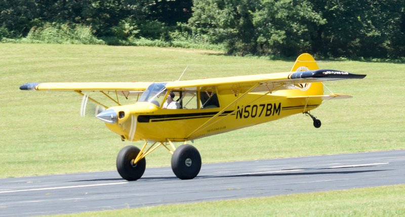 Westside Eagle Observer/MIKE ECKELS A pilot (possibly a student) lifts the tailwheel off the runway of his A-1B Husky as the aircraft gains speed prior to take-off at the Crystal Lake Airport near Decatur July 24. The pilot made a series of three full-stop landings, which is indicative of a cross-country training flight.