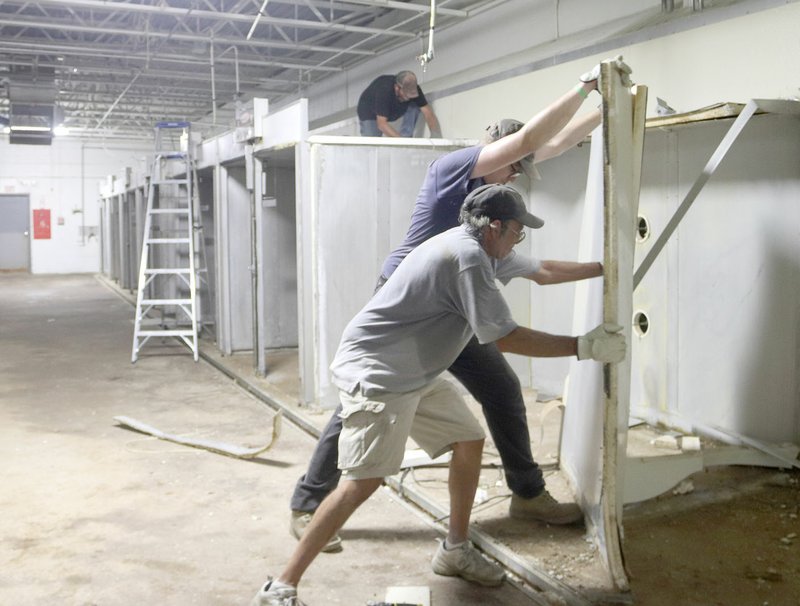 LYNN KUTTER ENTERPRISE-LEADER Ben Buscher of Watts, Okla., and Philip Walding of Lincoln, both employees with Polytech Plastic Molding &amp; Extrusion of Prairie Grove, tear out incubators and other equipment at the old hatchery formerly owned by Tyson Foods at 113 W. South St., in Lincoln. Polytech has purchased the building to use as a distribution center and for future growth of the company.