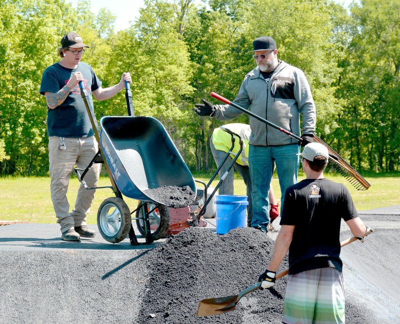 Janelle Jessen/Herald-Leader Volunteers helped Tom Ritz, of Pump Track USA, work on the track at City Lake Park in May. The pump track is just one of many features the new park has to offer, including mountain bike trails, walking trails, a bird blind and a 505-foot wooden bridge spanning the wetlands. A grand opening is planned for Aug. 10.