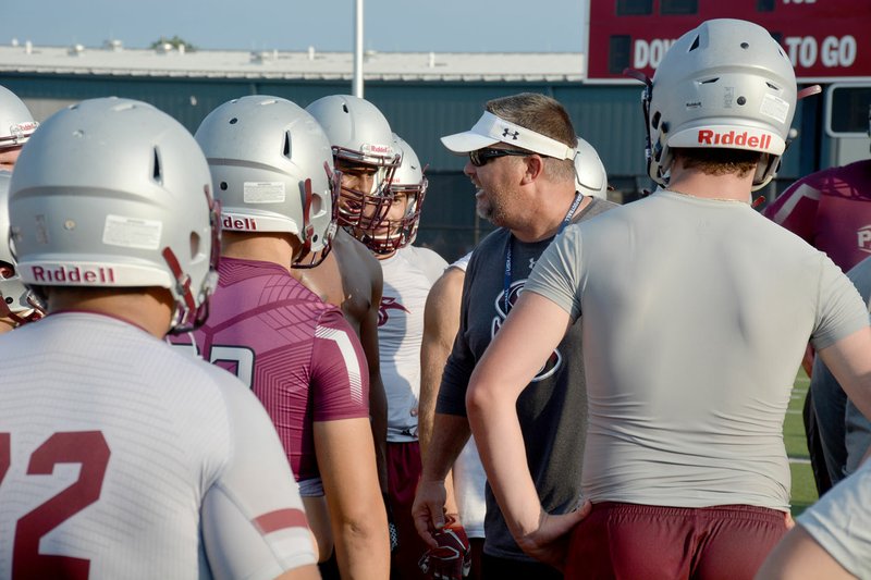 Graham Thomas/Herald-Leader The Siloam Springs Panthers listen as head football coach Brandon Craig gives instructions Monday during the first day of football practice.