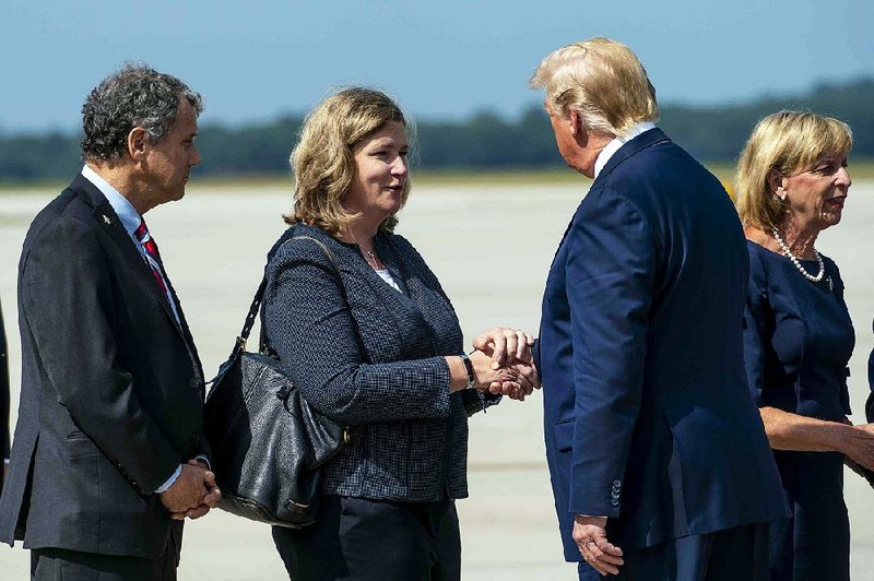 Mayor Nan Whaley of Dayton, Ohio, greets President Donald Trump as he arrives Wednesday at Wright-Patterson Air Force Base to visit with survivors and families of victims of the weekend shooting in Dayton. Trump also met with first responders and hospital staff members. 