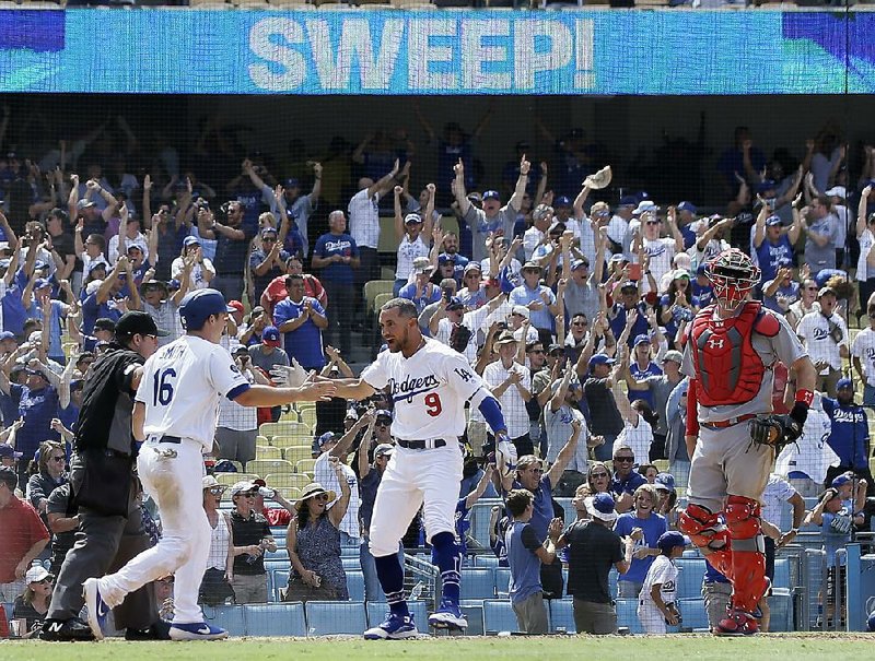 Will Smith (9) of the Los Angeles Dodgers is congratulated by  teammate Kristopher Negron after scoring the game-winning  run on a two-run single by Russell Martin in the ninth inning  Wednesday against the St. Louis Cardinals. 