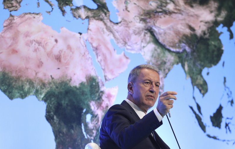 Turkey's Defense Minister Hulusi Akar addresses a meeting of his country's ambassadors, in Ankara, Turkey, Wednesday, Aug. 7, 2019. Akar says his country would like to establish a safe zone in northeast Syria jointly with the United States but would act alone if necessary.(Turkish Defence Ministry via AP, Pool)