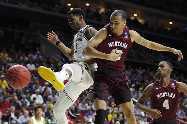 Michigan guard Charles Matthews, left, fights for a loose ball with Montana's Kendal Manuel and Sayeed Pridgett (4) during a first round men's college basketball game in the NCAA Tournament, Thursday, March 21, 2019, in Des Moines, Iowa. (AP Photo/Charlie Neibergall)

