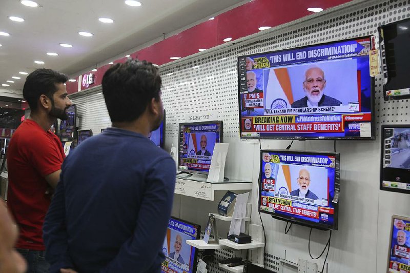 People at an electronics store in Jammu, India, watch a national address Thursday evening by Prime Minister Narendra Modi. “A new era has begun” with the revoking of Kashmir’s autonomy, Modi proclaimed. 