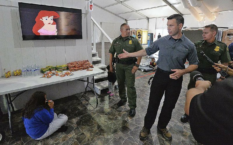 Acting Homeland Security Secretary Kevin McAleenan (second from right) tours a migrant center Thursday in Yuma, Ariz. He noted a steep drop in the number of children being detained but stressed that “we remain at and beyond crisis levels” in the number of people trying to cross the border illegally. 