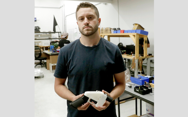 FILE - In this Aug. 1, 2018, file photo, Cody Wilson, with Defense Distributed, holds a 3D-printed gun called the Liberator at his shop, in Austin, Texas. (AP Photo/Eric Gay, File)