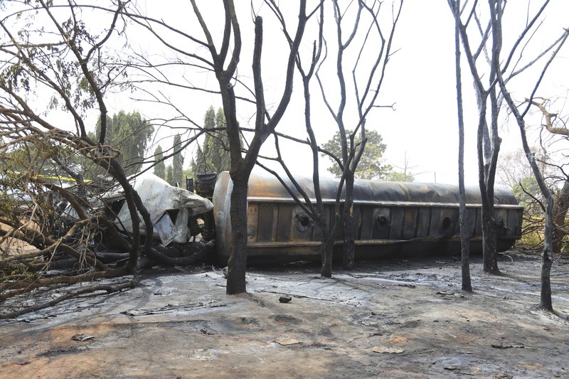 The wreckage of a fuel tanker lies among burnt out trees in Morogoro Township on Saturday Aug. 10, 2019. The damaged tanker truck exploded in eastern Tanzania on Saturday as people were trying to siphon fuel out of it, killing at least 62, in one of the worst incidents of its kind in the East African country. (AP Photo/ Khalfan Said)