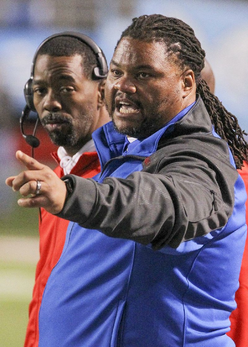 Little Rock McClellan Coach Maurice Moody (right) said he hopes to mold the Lions into state-title contenders again this season, the final one for the school.