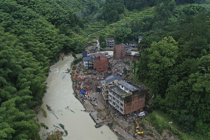 Rescuers search for victims Saturday after Typhoon Lekima caused a landslide in Yongjia County in China’s Zhejiang province. 