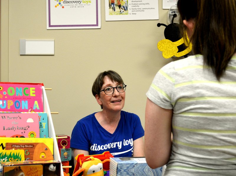 Sierra Bush/Siloam Sunday Polly Shafer, of Discovery Toys, speaks with an attendee of the Siloam Springs Regional Hospital's baby fair Aug. 6. The event included vendor displays, giveaways and obstetrician department tours for expectant mothers.