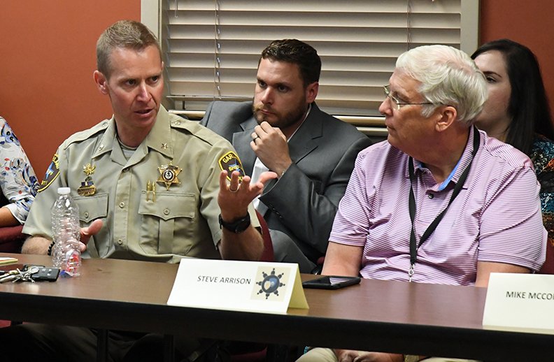 CRISIS INTERVENTION: Garland County Under Sheriff Jason Lawrence, left, discusses crisis intervention training for law enforcement officers Wednesday as Garland County Deputy Prosecutor Trent Daniels and Steve Arrison, CEO of Visit Hot Springs, listen during a roundtable meeting of public officials and community leaders at the Hot Springs Police Department.
