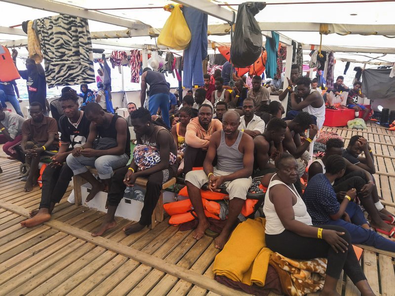 Migrants are seen aboard the Open Arms Spanish humanitarian boat as it cruises in the Mediterranean Sea, Friday, Aug. 9, 2019. Open Arms has been carrying 121 migrants for a week in the central Mediterranean awaiting a safe port to dock, after it was denied entry by Italy and Malta. (AP Photo/Valerio Nicolosi)
