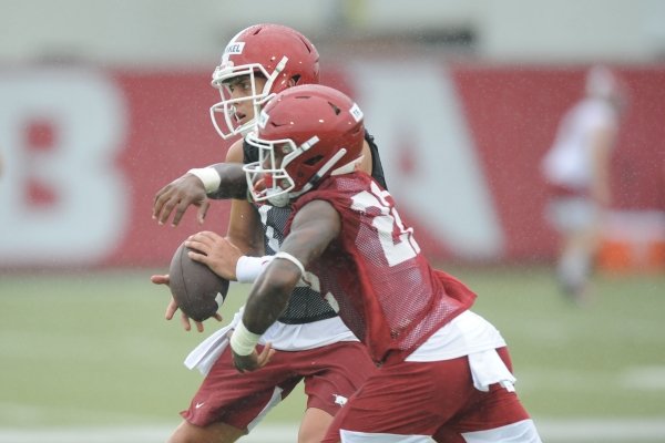 Arkansas quarterback Nick Starkel (left) fakes a handoff to running back Trelon Smith Saturday, Aug. 3, 2019, during practice at the university practice field in Fayetteville. Visit nwad.com/photos to see more photographs from the practice.