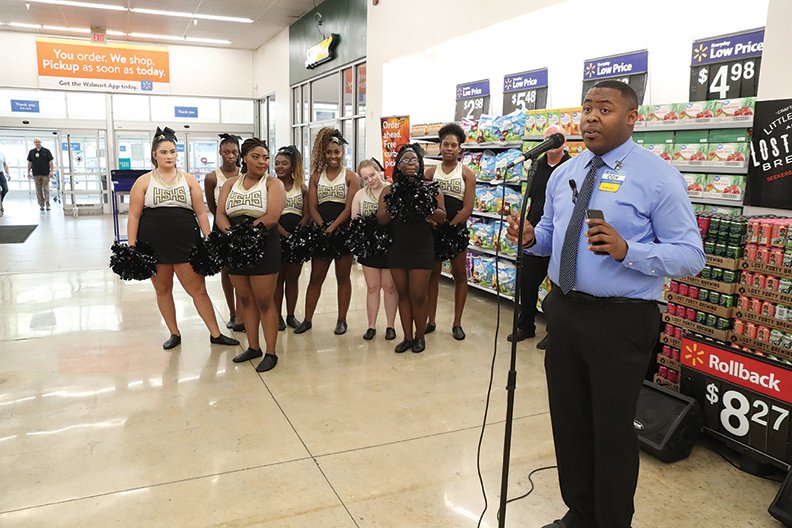 Wal-Mart store manager Coy Jackson Jr., speaks to a group at a reopening ceremony for the Wal-Mart store on Albert Pike Road Friday, August 2, 2019. Inculded in the event, Jackson presented three grants Friday on behalf of Wal-Mart including one to the Hot Springs High School T-Steppers, pictured at left, and the Jakson House and the Hot Springs Police Department. (The Sentinel-Record/Richard Rasmussen)