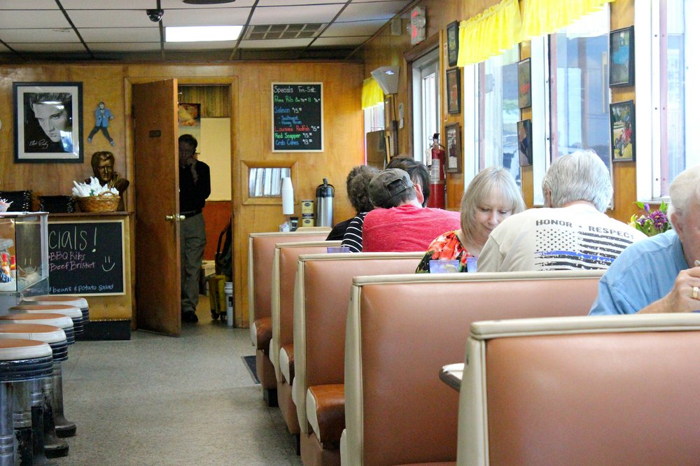Dale Summitt surveys an afternoon crowd at the diner from the door of his office while talking on the phone. (Special to the Democrat-Gazette/ELI CRANOR)