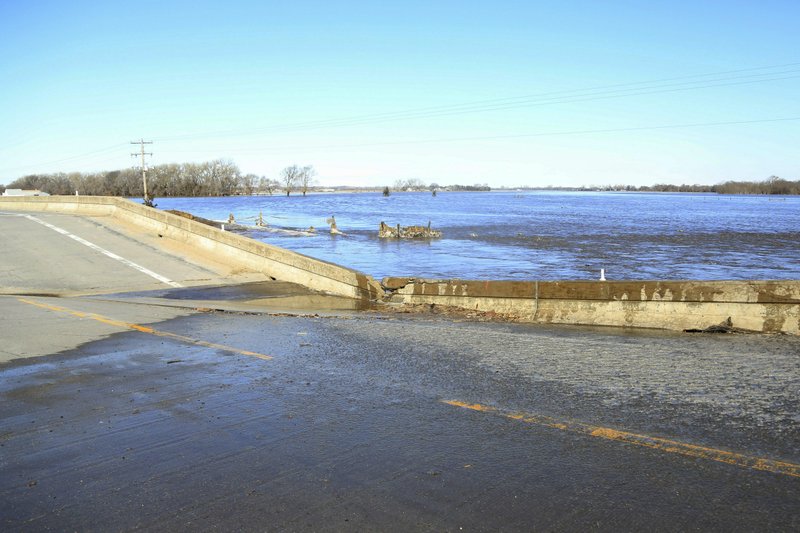 FILE - In this Friday, March 15, 2019 file photo, a bridge brought down by flood waters is seen near Norfolk, Neb. The Associated Press tallied about $1.2 billion of damage in 24 states based on preliminary assessments of public infrastructure categories established by the Federal Emergency Management Agency. The tally includes damage to roads and bridges, utilities, water control facilities, public buildings and equipment, and parks. (AP Photo/Nati Harnik)