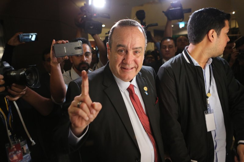 Alejandro Giammattei, presidential candidate with the Vamos party, shows shows his ink stained finger, which means he voted in the presidential election, as he arrives to his campaign headquarters to await results, at a hotel in Guatemala City, Sunday, Aug. 11, 2019. Guatemalans voted Sunday in a presidential runoff pitting former first lady Sandra Torres against conservative Alejandro Giammattei in a nation beset by poverty and unemployment, and dealing with migration issues. (AP Photo/Oliver de Ros)