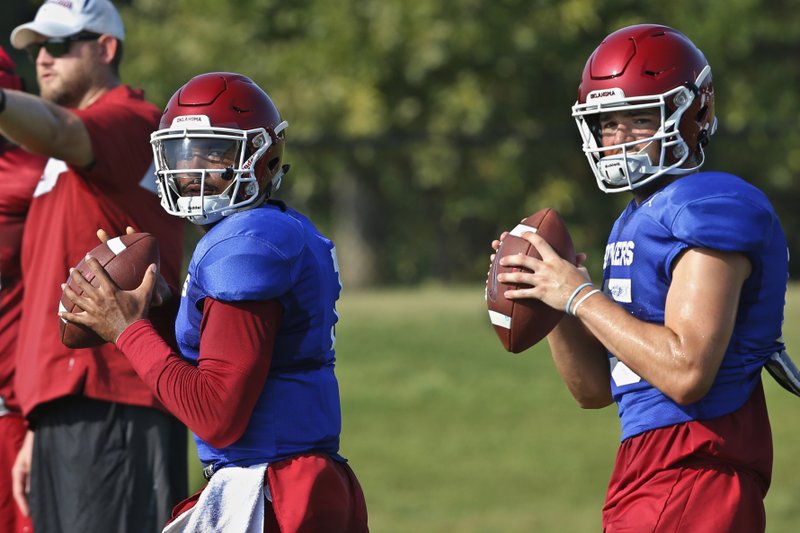 FILE - In this Monday, Aug. 5, 2019, file photo, Oklahoma quarterbacks Jalen Hurts, left, and Tanner Mordecai, right, throw during NCAA college football practice in Norman, Okla. Hurts is competing with Mordecai, a redshirt freshman, and Spencer Rattler, a true freshman, to become starting quarterback. (AP Photo/Sue Ogrocki, File)