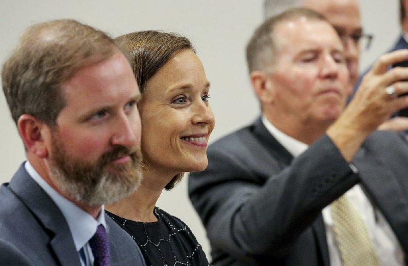 Jacob Gibbs (left) and Maury Peterson of Hope Academy of Northwest Arkansas watch Tuesday in Little Rock as their charter school application is approved by the Charter Authorizing Panel.