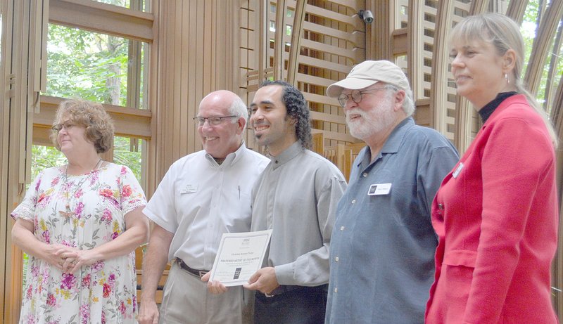 Keith Bryant/The Weekly Vista Bella Vista Arts Council artist of the month selection committee member Sara Parnell (left) stands with Mayor Peter Christie, who presented a certificate to the August artist of the month cellist, Christian Serrano-Torres. Arts council members Terry Wilson and Demara Titzer stand by as well.