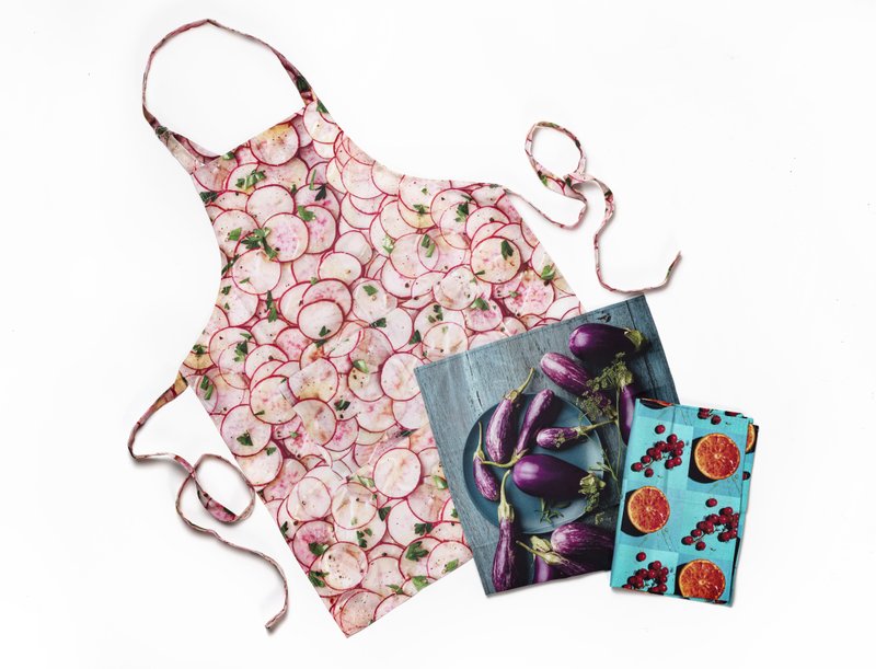 An apron and dish towels from Renee Comet's line that features her full-color food photos. (Tony Cenicola/The New York Times)