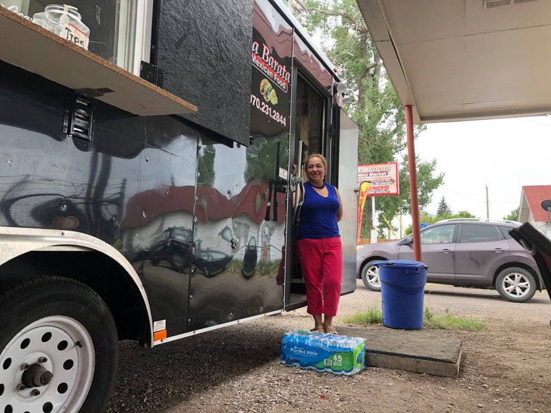 In this Aug. 1, 2019 photo Nena Hermosillo stands outside her taco truck in Cheyenne, Wyo. Cheyenne-based Taco John's, which has nearly 400 locations in 23 states, recently sent Freedom's Edge Brewing Co. in Cheyenne a cease-and-desist letter for using"Taco Tuesday" to advertise the taco truck parked outside on Tuesdays. (AP Photo/Mead Gruver)