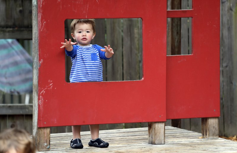  In this Aug. 27, 2018, Vincent Seeborn, 2, reaches out from a structure on the playground at the Wallingford Child Care Center in Seattle. Child care costs in most states exceed federal subsidy payments provided to low-income parents, according to a newly released report from the Department of Health and Human Services Office of Inspector General, leaving working families with few affordable options. (AP Photo/Elaine Thompson, File)