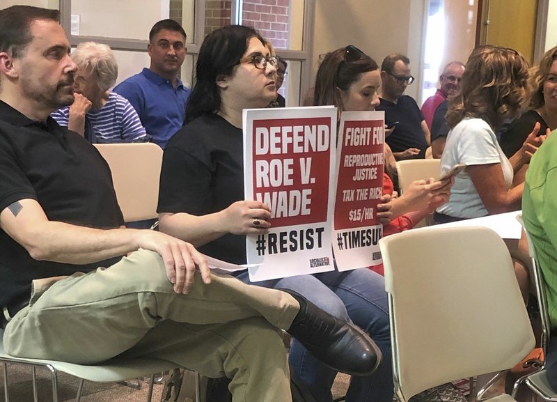 Sheila Czech holds posters Tuesday supporting her feelings on a pro-life resolution before Springdale's City Council vote. Council members passed the resolution proclaiming the city as pro-life.