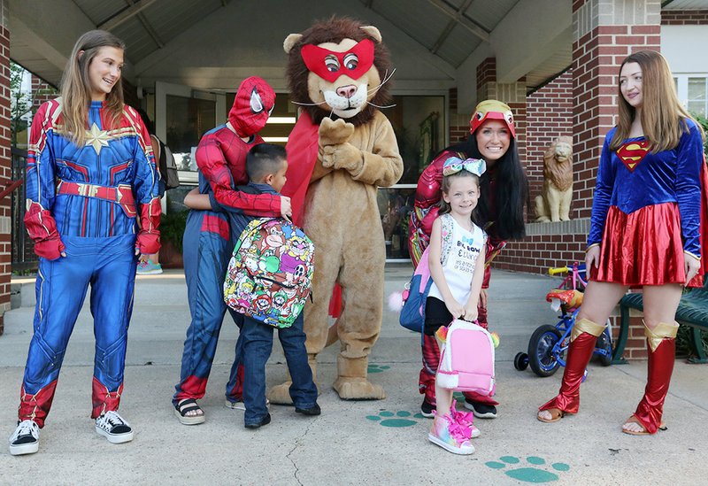 Lee the Lion (center) stands with costumed curriculum and instruction students with the University of Arkansas greet students and parents Tuesday at Lee Elementary School in Springdale. Tuesday was the first day of the school year for the Springdale School District.NWA Democrat-Gazette/DAVID GOTTSCHALK
