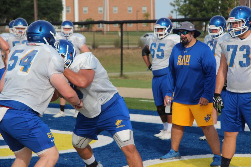 SAU offensive line coach Boomer Cunningham watches his Muleriders go through a drill Wednesday morning at Wilkins Stadium. The Muleriders open the season Thursday, Sept. 5, at Southern Nazarene.