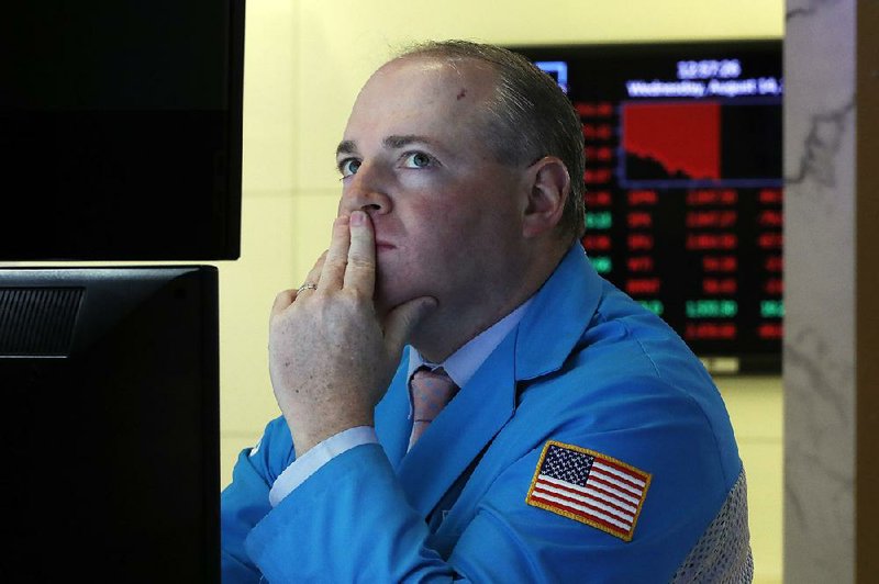 Specialist Edward Loggie watches stock prices drop Wednesday as he works on the floor of the New York Stock Exchange. A day after a strong rally, skittish investors dumped shares in droves. 