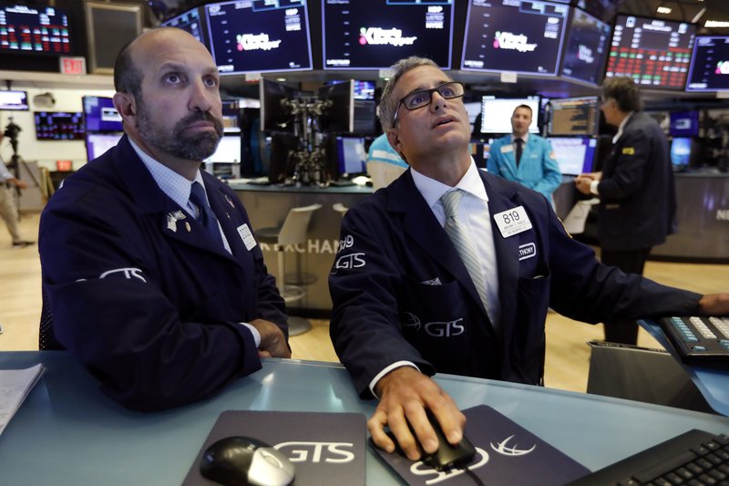 FILE - In this Aug. 13, 2019, file photo specialists James Denaro, left, and Anthony Rinaldi work on the floor of the New York Stock Exchange. (AP Photo/Richard Drew, File)

