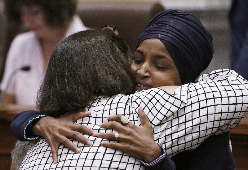 U.S. Rep. Ilhan Omar (facing camera) gives hugs and handshakes Thursday in the Minneapolis City Council chamber before a budget address by Mayor Jacob Frey.