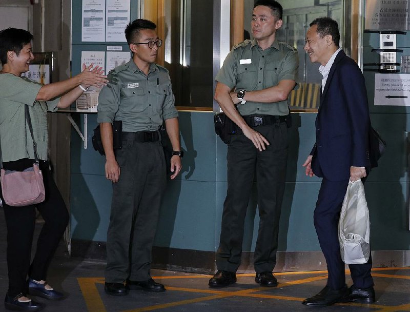 Occupy Central leader Benny Tai (right) is greeted Thursday by pro-democracy lawmaker Helena Wong as he leaves the High Court in Hong Kong.