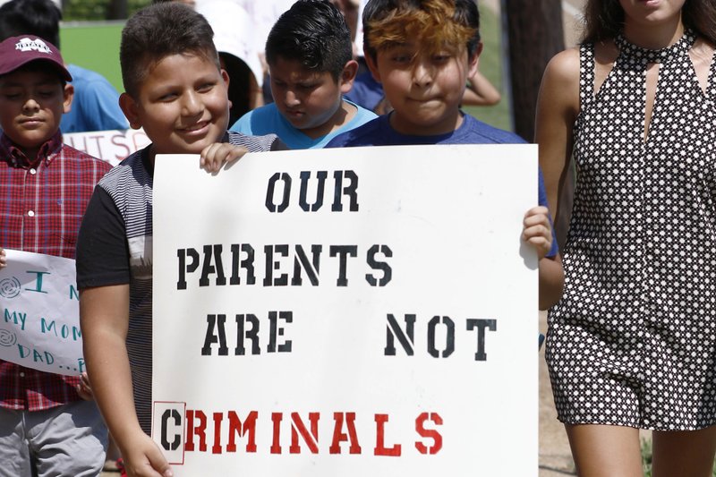 FILE - In this Aug. 11, 2019, file photo, children of mainly Latino immigrant parents hold signs in support of them and those individuals picked up during an immigration raid at a food processing plant, during a protest march to the Madison County Courthouse in Canton, Miss. Unauthorized workers are jailed or deported, while the managers and business owners who profit from their labor often aren&#x2019;t. Under President Donald Trump, the numbers of owners and managers facing criminal charges for employing unauthorized workers have stayed almost the same. (AP Photo/Rogelio V. Solis, File)