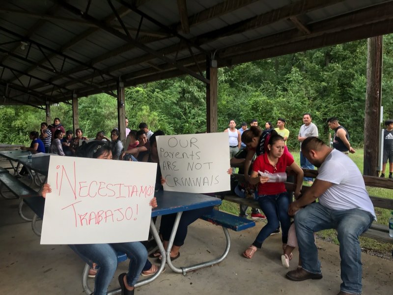 Workers from PH Foods and their supporters hold signs on Tuesday, Aug. 13, 2019 in Morton, Miss., including one that says &#x201c;We need work!&#x201d; in Spanish after workers from the chicken processing plant said they were fired. Workers say the plant fired the majority of remaining workers days after federal agents arrested 99 people there for immigration violations. (AP Photo/Terry Truett)