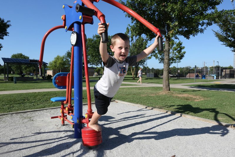 NWA Democrat-Gazette/DAVID GOTTSCHALK Louis Garcia, 6, uses the chest press Thursday at Luther George Grove Street Park in Springdale. Louis and his family, from Fayetteville, visit the park two times a week to use the exercise and playground equipment. Plans for the park were unveiled Thursday night at a public meeting.