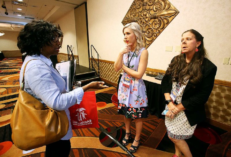 Allison Abromitis (center) and her mother, Bliss Deeter (right), visit with Cheryl Johnson after Abromitis spoke during an immunization event Friday at the Wyndham Hotel in North Little Rock. 