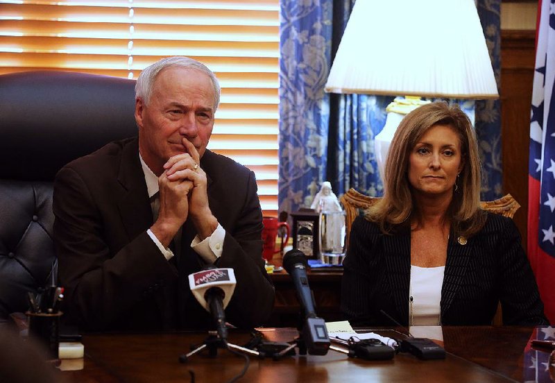 FILE - Gov. Asa Hutchinson (left) and Amy Fecher (right), then the state's chief transformation officer, listen to a question during a press conference on Wednesday, Aug. 7, 2019, at the state Capitol in Little Rock. (Arkansas Democrat-Gazette/Thomas Metthe)