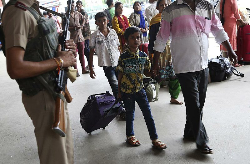 A child passes a paramilitary soldier Saturday at a train station in Bangalore in southern India. Government officials issued a security alert late Friday but by Saturday claimed it was only a drill. 