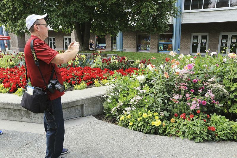 Paul Leake of Florida photographs a dahlia garden Thursday in Anchorage, Alaska. 