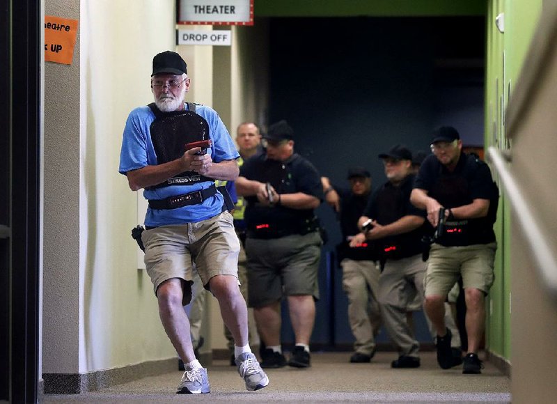 Stephen Hatherley leads fellow trainees through a hallway in July during a simulated gunfight at the Fellowship of the Parks church campus in Haslet, Texas. 