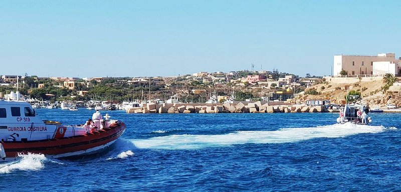Italian coast guard boats help in the transfer of the migrant children Saturday near the Sicilian island of Lampedusa. 