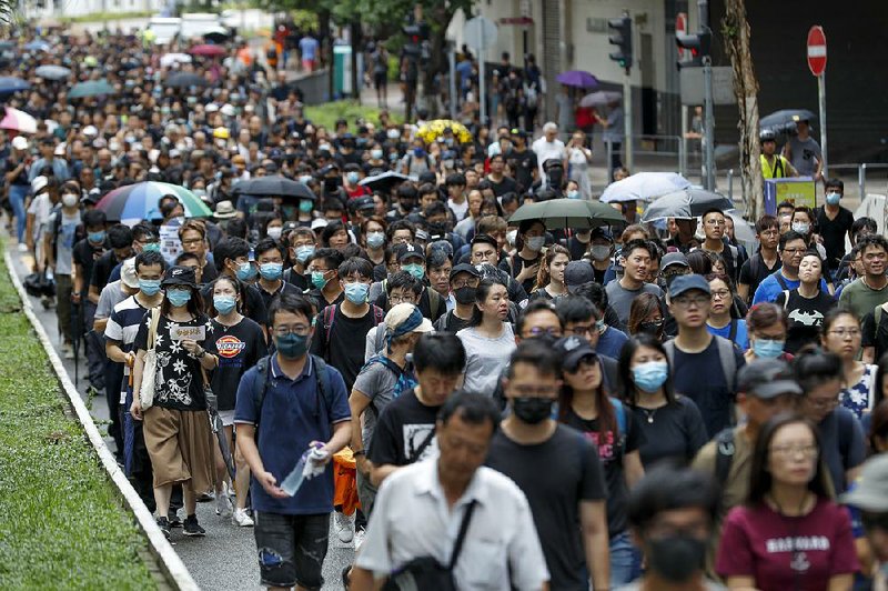 Pro-democracy demonstrators march Saturday in a Hong Kong street. Backers of the semiautonomous Chinese territory’s government held their own rally elsewhere in the city. 