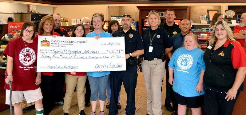 Sierra Bush/Siloam Sunday Members of Special Olympics Arkansas and Special Olympics athletes accept a $69,271 check from Casey's General Store employees, Coca-Cola and the Siloam Springs Police Department on Wednesday after a month-long fundraising effort by Casey's employees. In June, store employees nationwide asked customers if they would like to round up their purchase to the nearest dollar to donate to the cause, according to a press release from the company. The Siloam Springs Casey's was the top fundraiser in the state, bringing in nearly $6,000, so the statewide check was presented at the local store, according to store manager Randie Toto. The funds raised will aid more than 15,000 Special Olympics athletes in Arkansas, according to Amanda Whitley, Special Olympics coordinator of special events for Arkansas. This is the third year in a row that Siloam Springs Casey's has been the top fundraiser for Special Olympics Arkansas, Toto said.