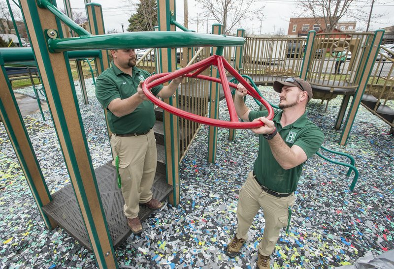 File Photo/NWA Democrat-Gazette/BEN GOFF @NWABENGOFF Zach Skinner (right) and Nick Pilgrim with Bentonville Parks and Recreation replace a piece of playground equipment April 4 at Dave Peel Park in downtown Bentonville